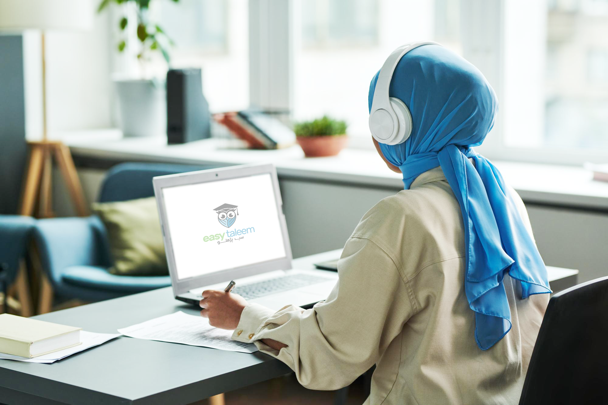 Female student wearing hijab learning online with Easy Taleem LMS on laptop